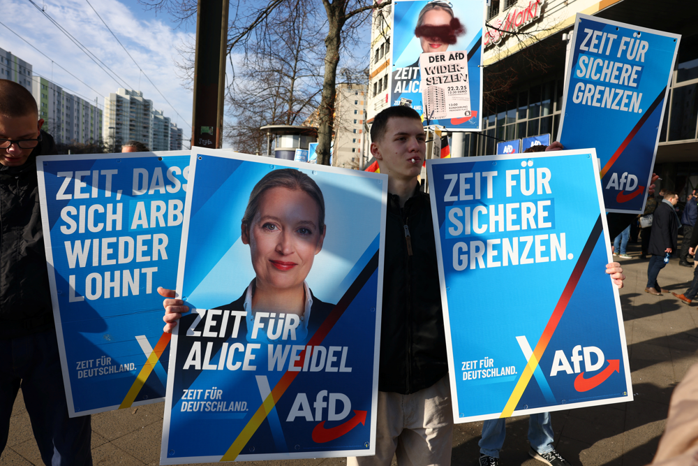 Supporters of the Alternative for Germany party (AfD) hold placards as they take part in an AfD campaign rally in Hohenschoenhausen, Berlin, Germany, February 22, 2025. REUTERS/Christian Mang