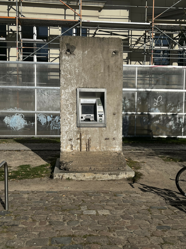 BERLIN, IZLOŽBA NEMA IZLAZA - Bankomati se mogu naći na mnogim turističkim mjestima, uključujući i ispred Hamburger Bahnhofa. No ovdje se novac ne može podići. Za svoju instalaciju umjetnički dvojac Elmgreen & Dragset ugradio je nefunkcionalni bankomat u originalni segment Berlinskog zida. Elmgreen & Dragset u svojoj instalaciji referiraju na način na koji su se dvije njemačke države ponovno spojile nakon 1990. U određenom smislu, kapitalistički Zapad „proširio se“ na komunistički Istok. Naslov upućuje na kip slobode kao simbol obećanja neograničene slobode"